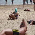 Paplūdimyje kinės dėvi veido kaukes Paplūdimyje kinės dėvi veido kaukes